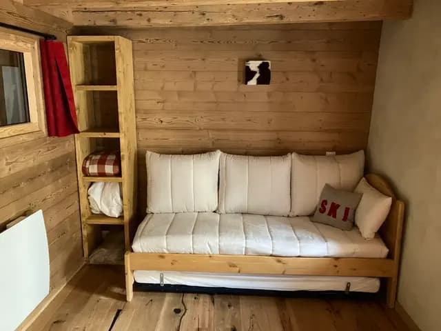 Banquette-lit gigogne aux coussins écrus et coussin SKI