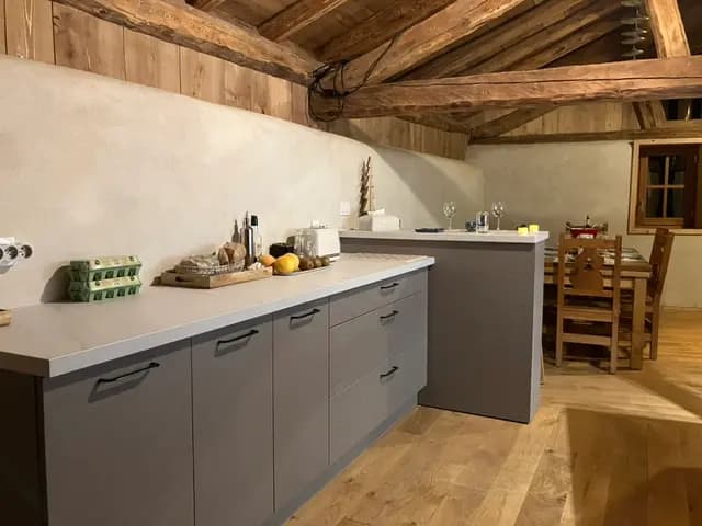La cuisine et son long plan de travail sous la charpente