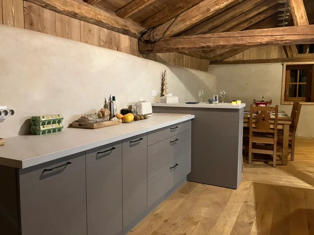 La cuisine et son long plan de travail sous la charpente