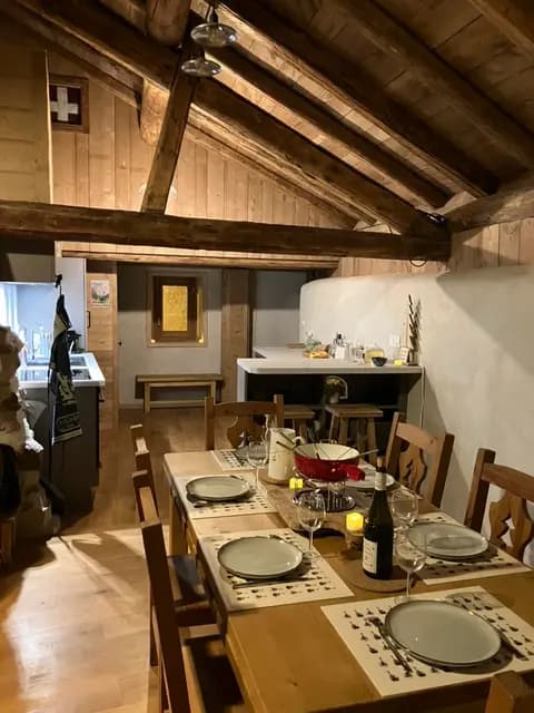 Table dressée pour une fondue savoyarde sous la charpente