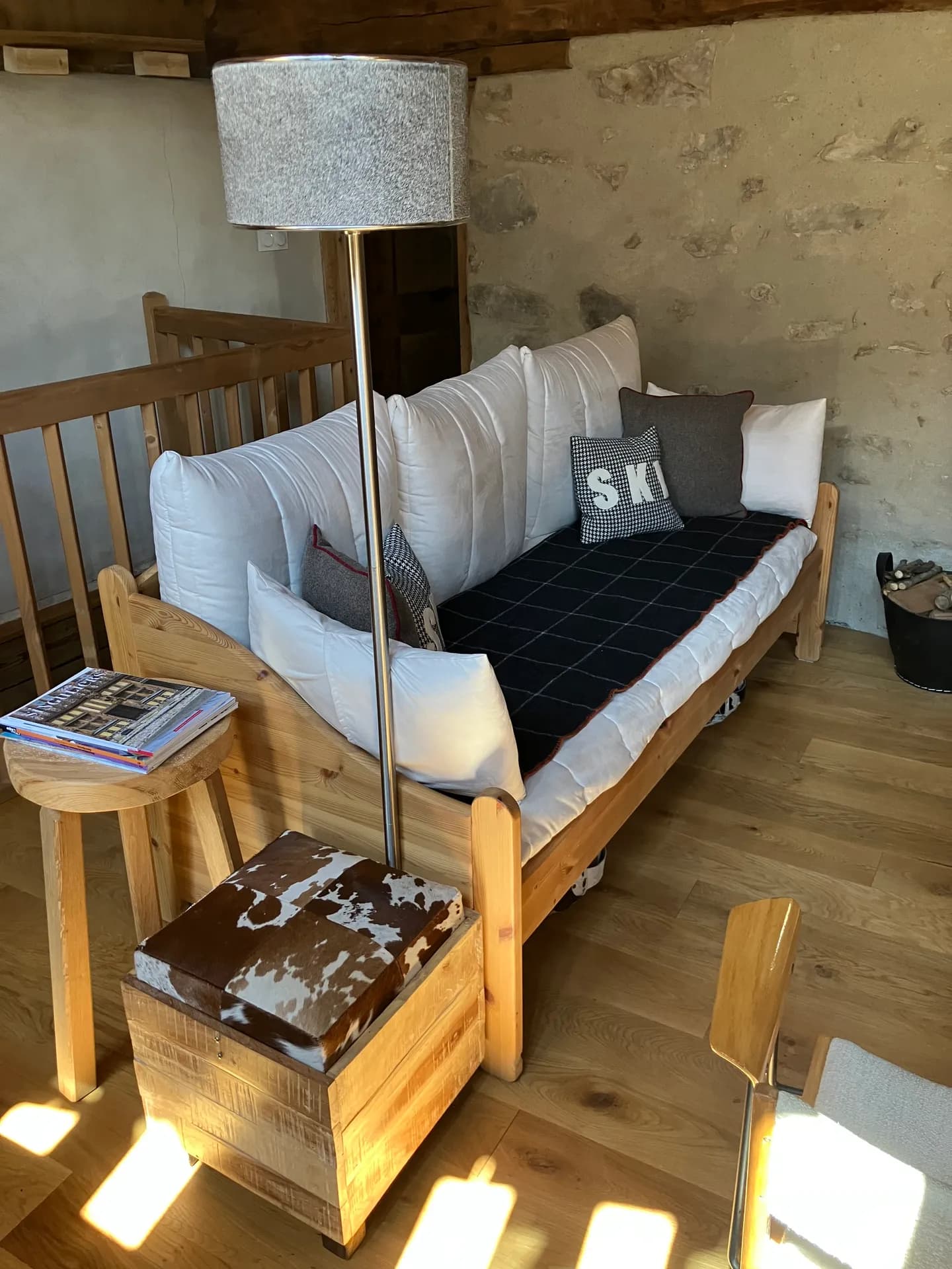 Canapé en tissu clair avec table basse en bois et coussins à motifs dans un chalet