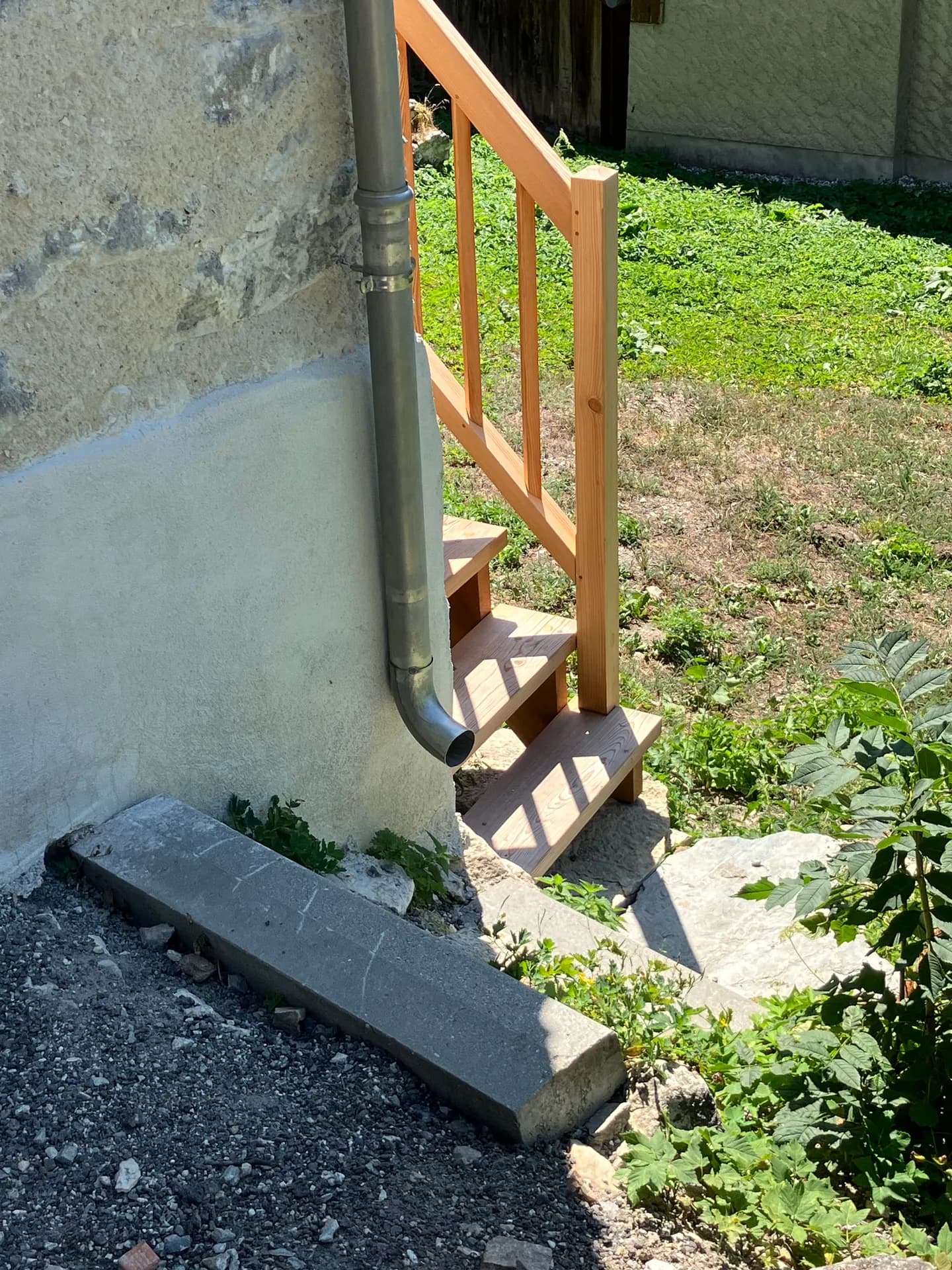 Escalier en bois extérieur menant à une terrasse en pierre