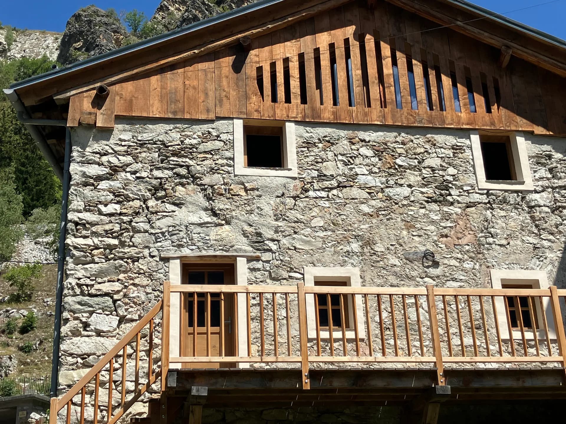 Escalier extérieur en bois menant à une chambre mansardée