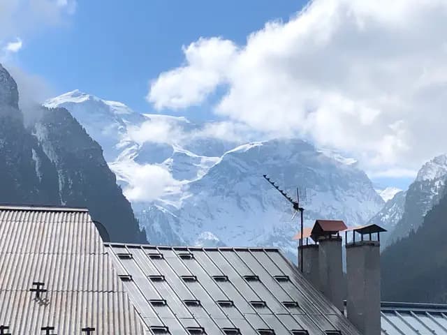 Vue depuis le balcon-terrasse sur les toits du hameau et les sommets enneigés