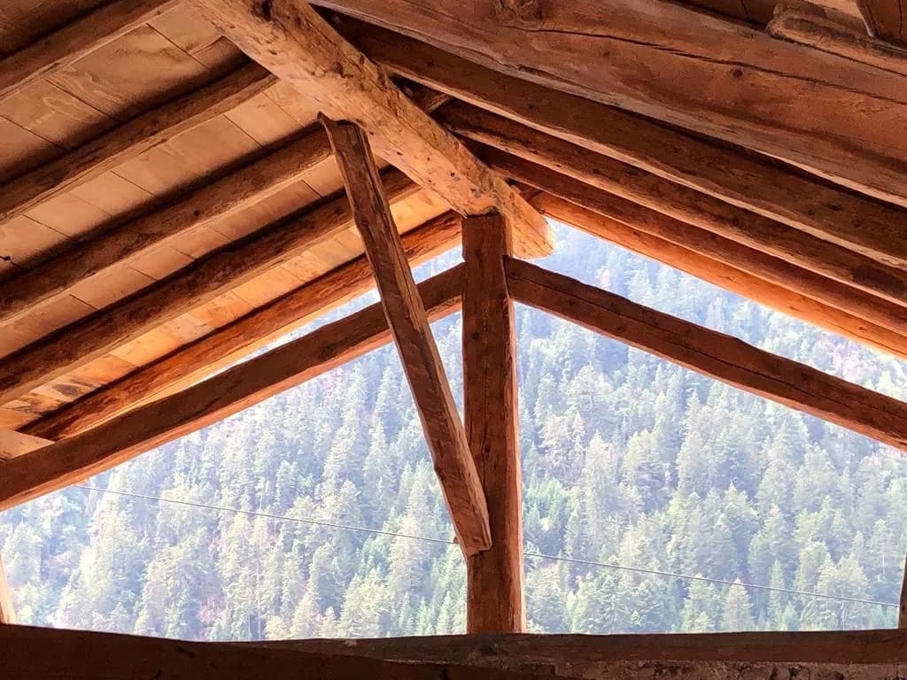 Toit en bois avec lucarne et vue sur la montagne enneigée