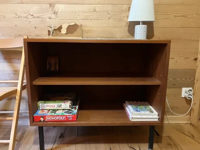 Cheminée en pierre avec jeux et livres sur le manteau