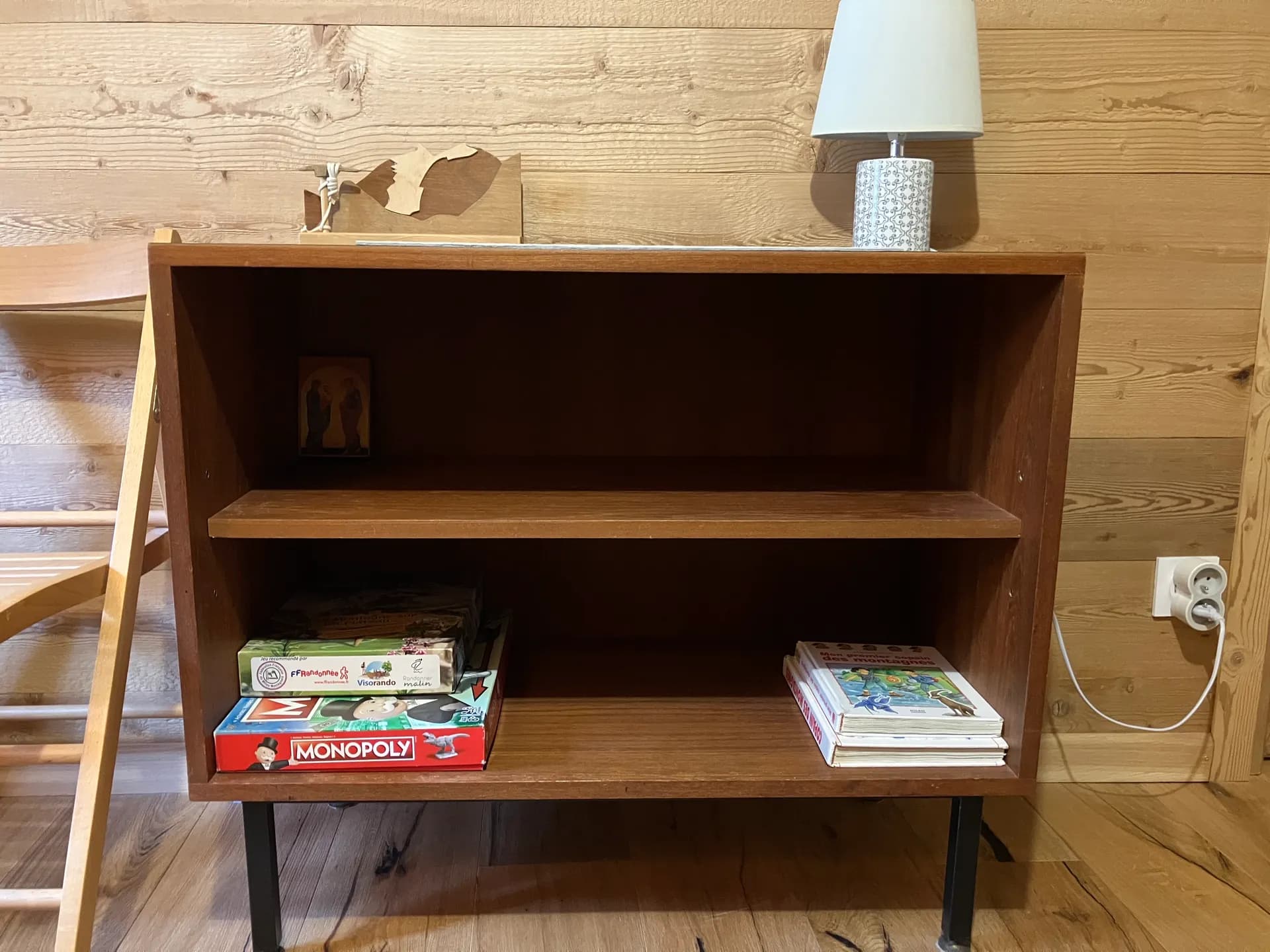 Cheminée en pierre avec jeux et livres sur le manteau