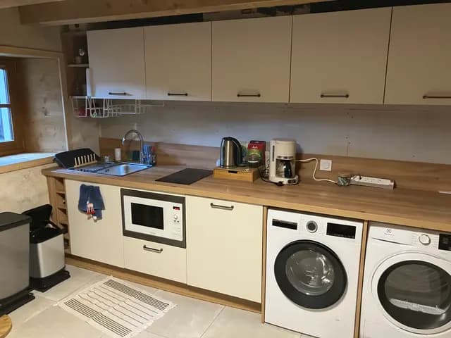 Cuisinière à induction et four intégrés sous hotte dans cuisine équipée