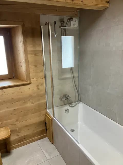 Cabine de douche en bois avec paroi vitrée et robinetterie chromée