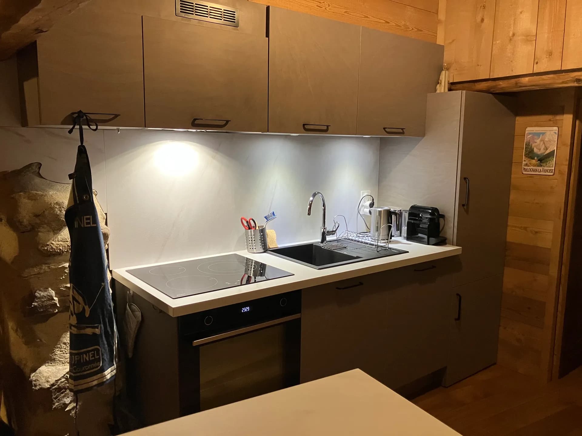 Cuisine équipée avec évier, plaques de cuisson et meubles en bois