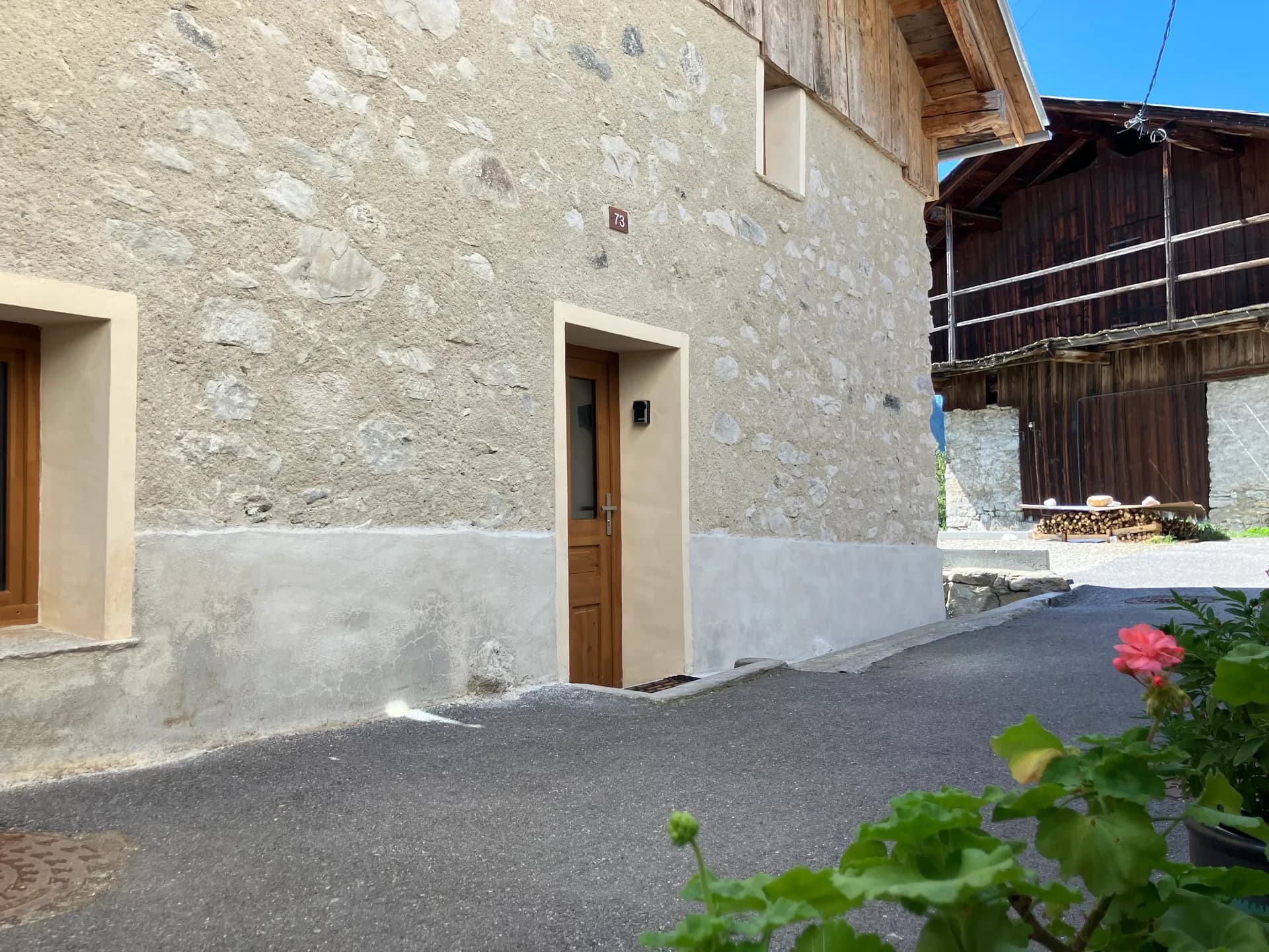 Entrée du chalet avec porte en bois et allée en gravier