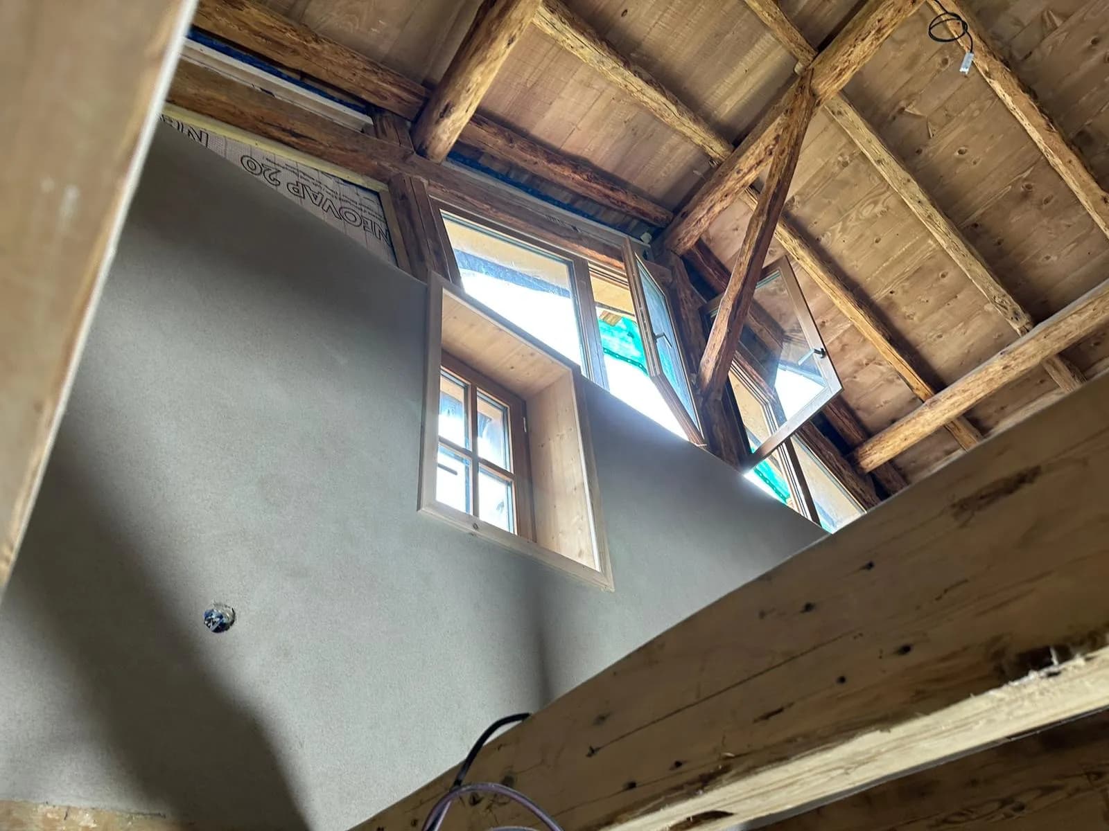 Escalier en bois avec fenêtre en demi-lune éclairant l'entrée