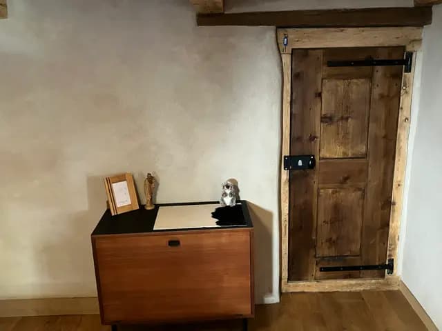 Meuble TV en bois clair avec cadre photo et horloge murale dans séjour