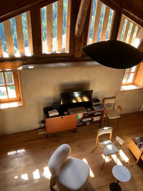 Salon avec poêle à bois, table et chaises en bois clair