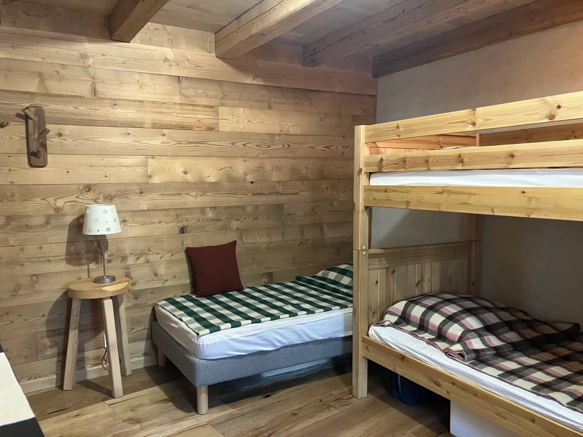 Chambre avec lit double, table de chevet, fauteuil et rangements en bois