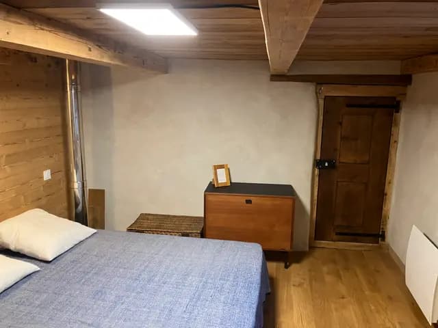 Le lit face à la commode vintage et à la vieille porte en bois d'origine
