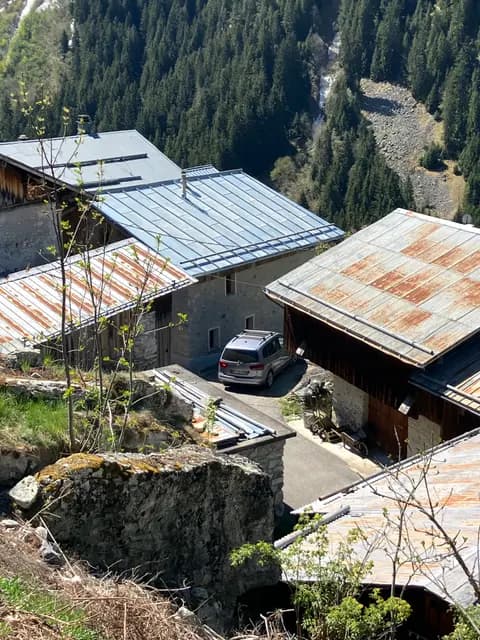 La place de parking du chalet entre les toits du hameau, à flanc de vallée