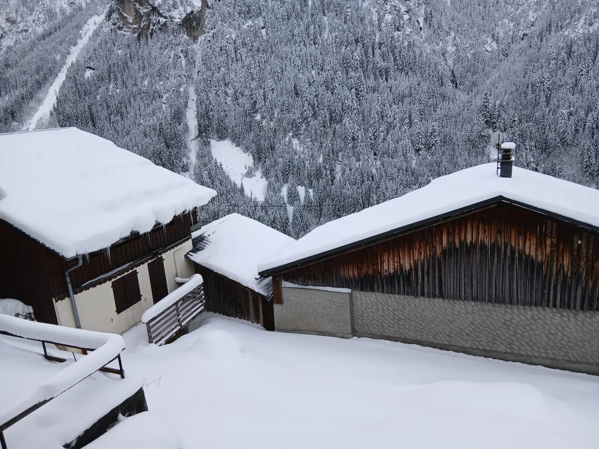 Terrasse en bois sous la neige avec bancs et table