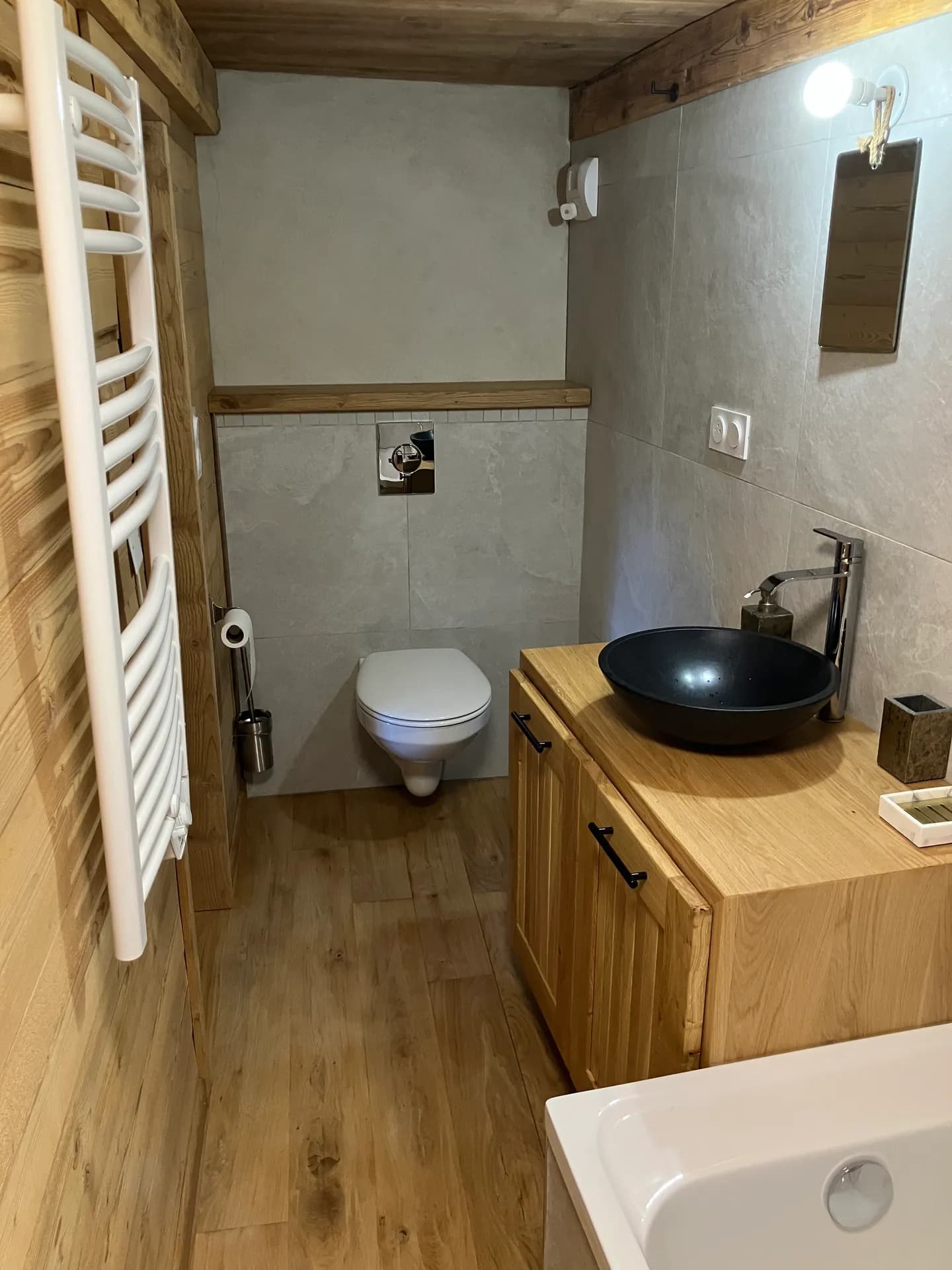 Salle de bain avec baignoire, lavabo et WC sous fenêtre