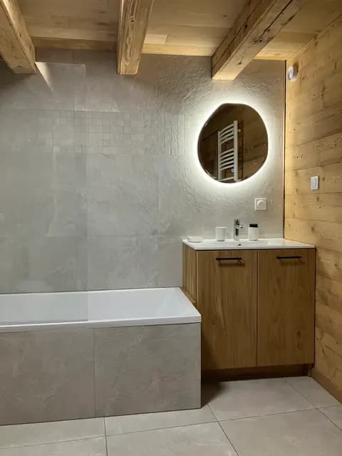 Salle de bain avec meuble sous vasque, miroir et carrelage blanc