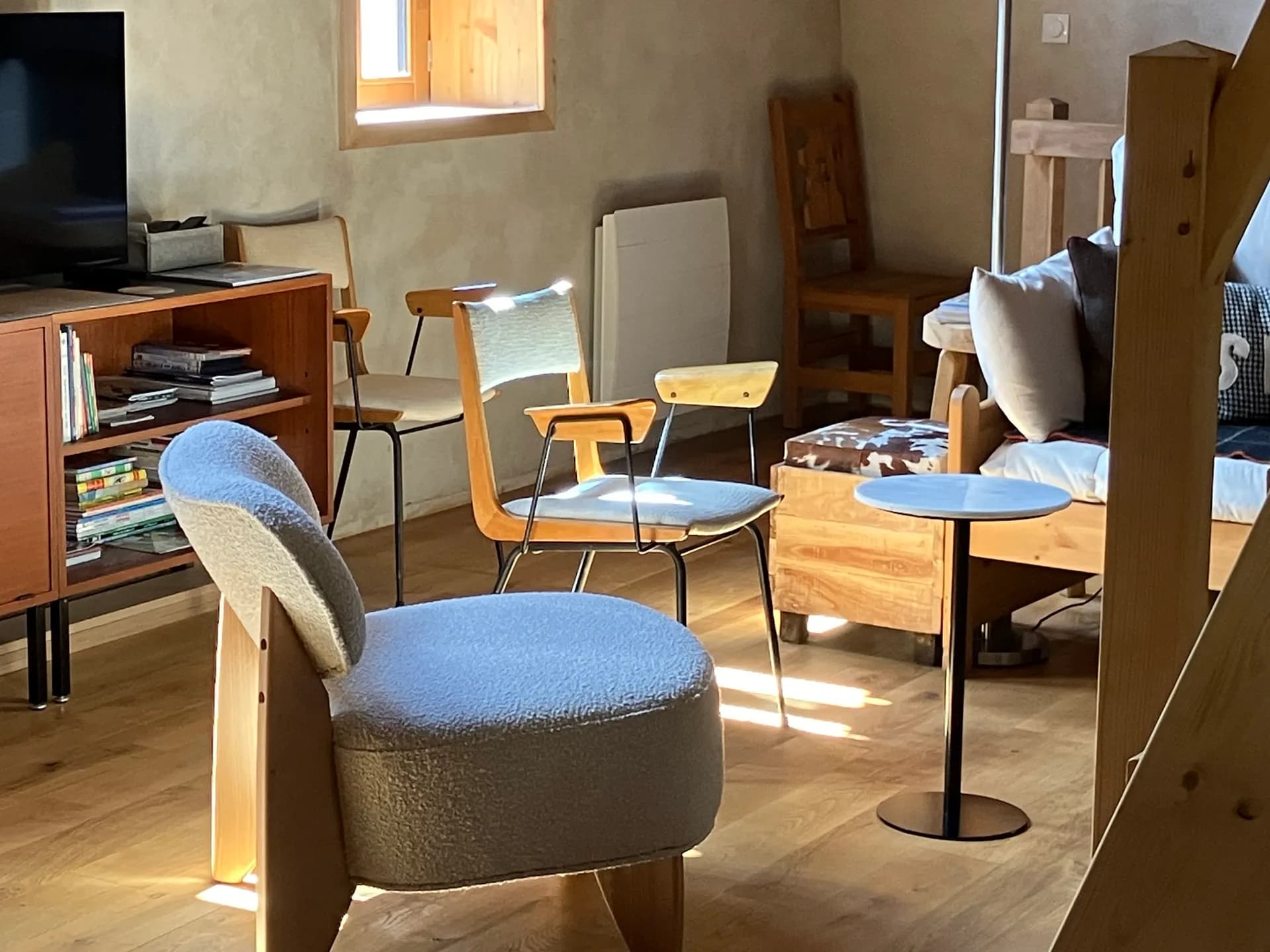 Table en bois avec quatre chaises et pouf bleu dans pièce à vivre