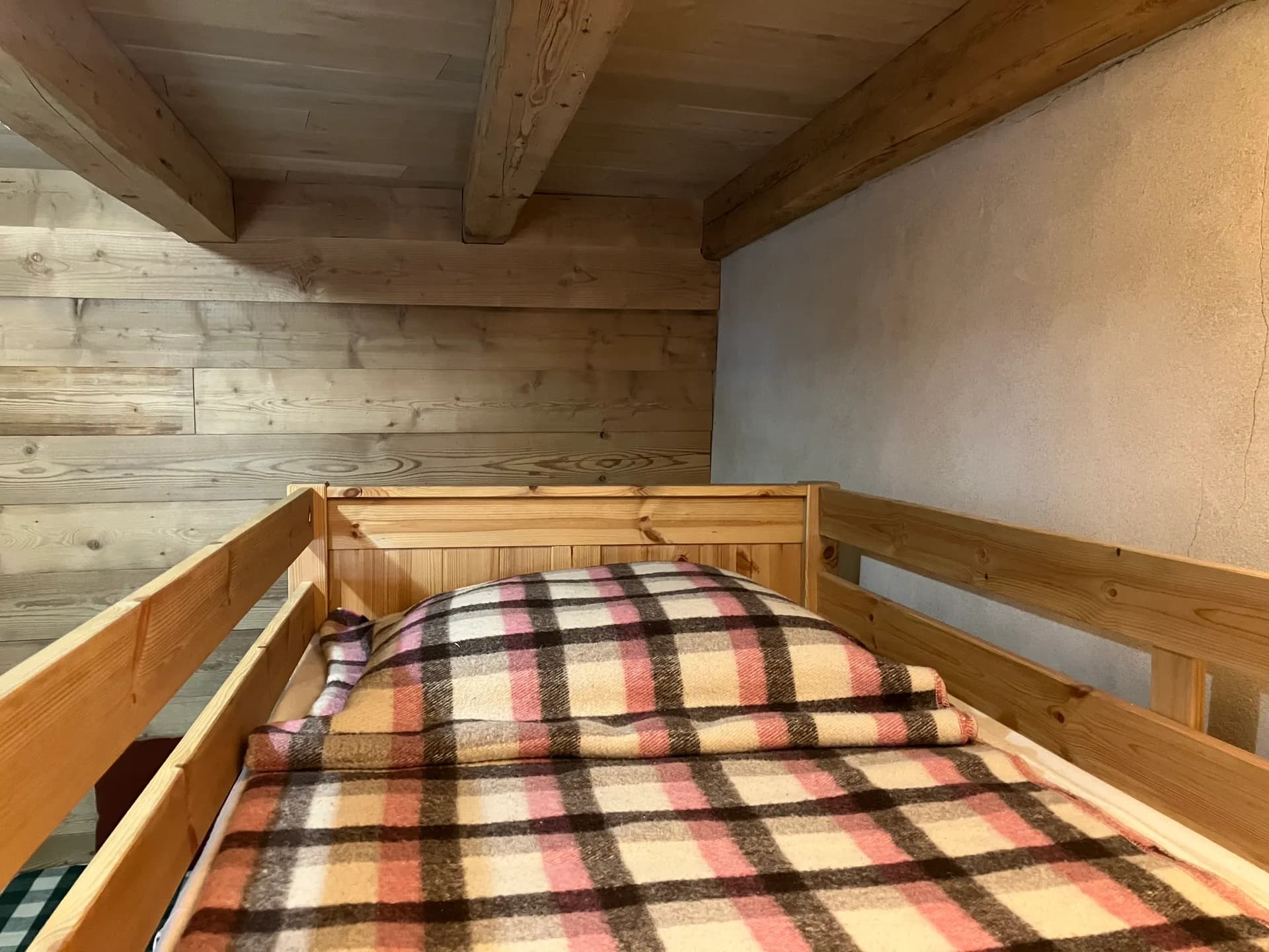 Lit superposé en bois avec matelas à motifs dans chambre mansardée