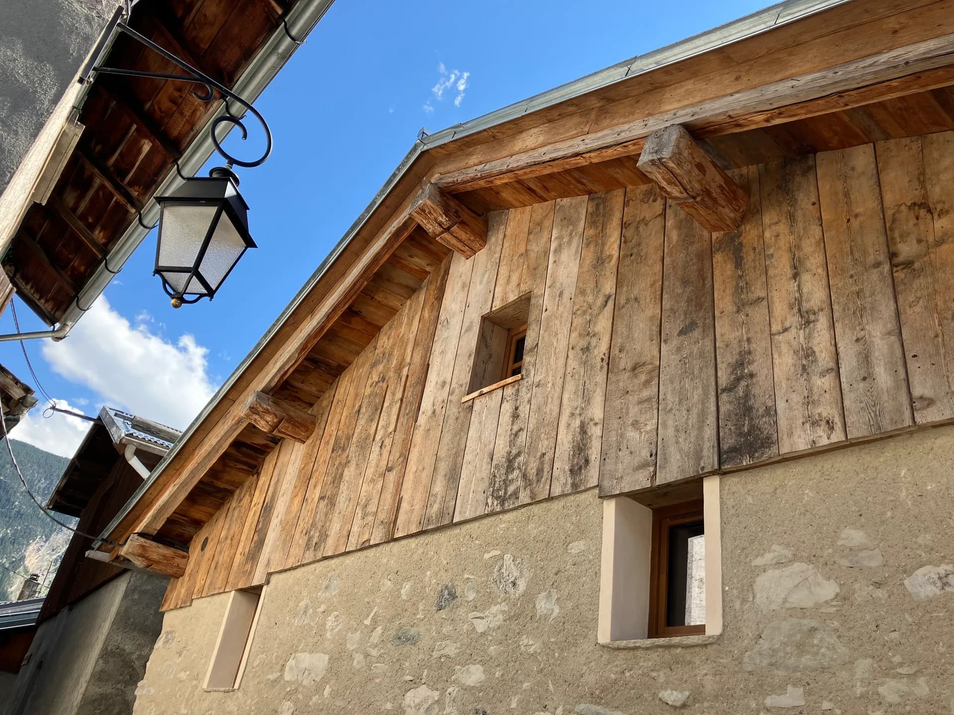 Escalier en bois extérieur menant à une porte en pierre