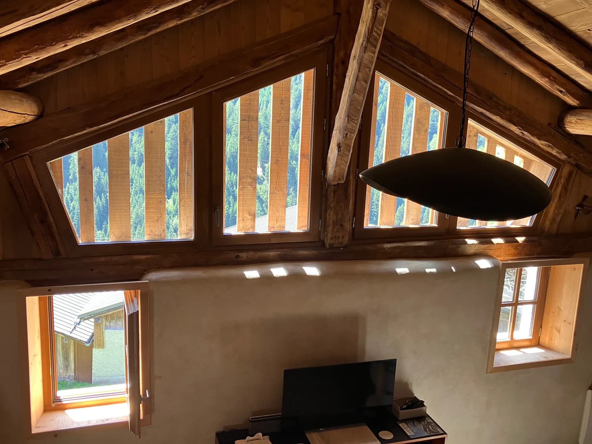 Salle à manger avec grande baie vitrée et poêle à bois