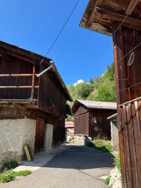 Chemin en pierre bordé de chalets en bois sous ciel bleu