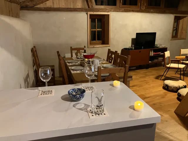 Cuisine ouverte avec évier, verres et bouilloire sur plan de travail en bois