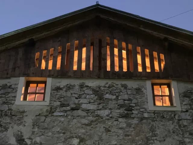 Cheminée en pierre avec conduit en bois éclairé