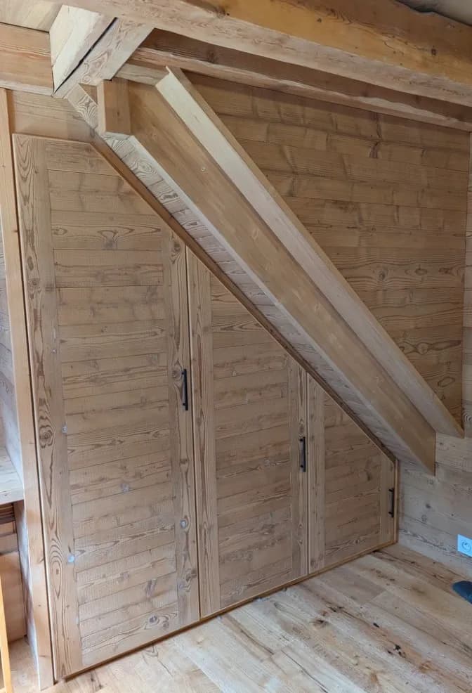 Les placards en vieux bois épousant la pente de l'escalier