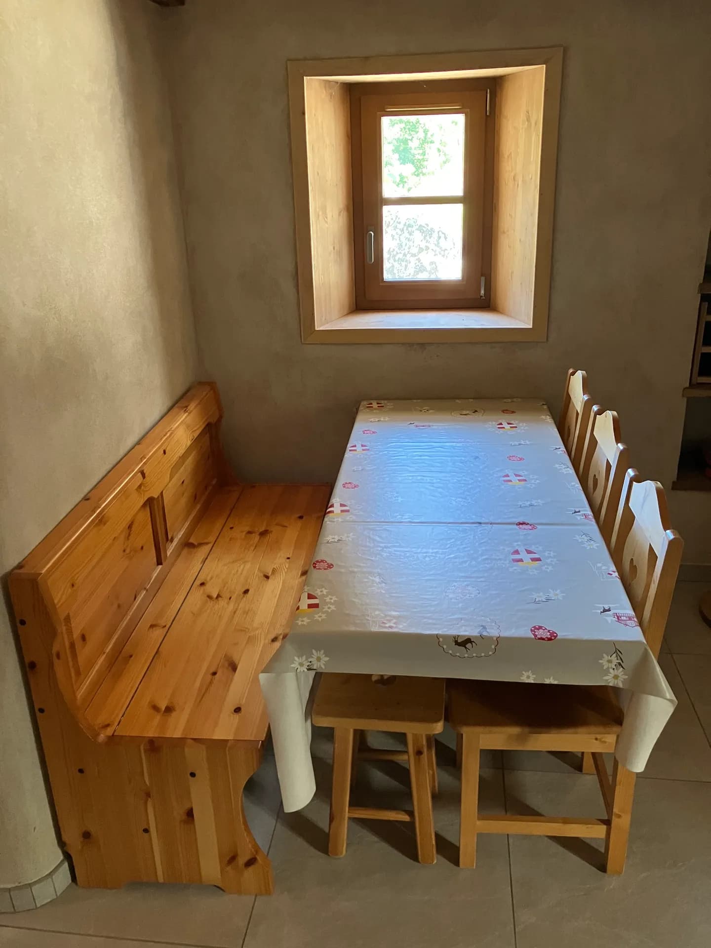Table en bois avec vaisselle et bougies, vue depuis la cuisine
