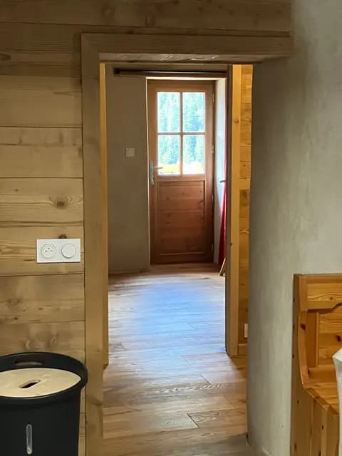 Salle de bain avec meuble en bois clair et miroir à petits carreaux